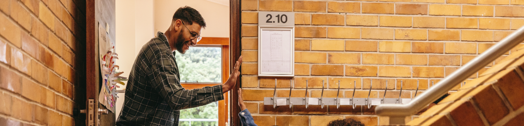 Teacher high fives students as they enter his class